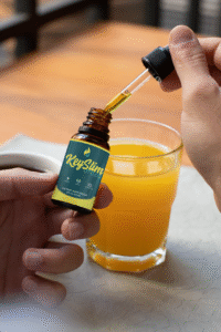 Man adding KeySlim drops to his orange juice
